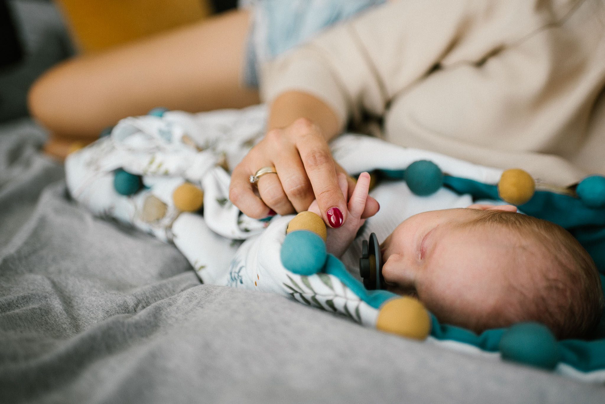 Mama trzyma noworodka za rączkę - sesja noworodkowa lifestyle w Poznaniu