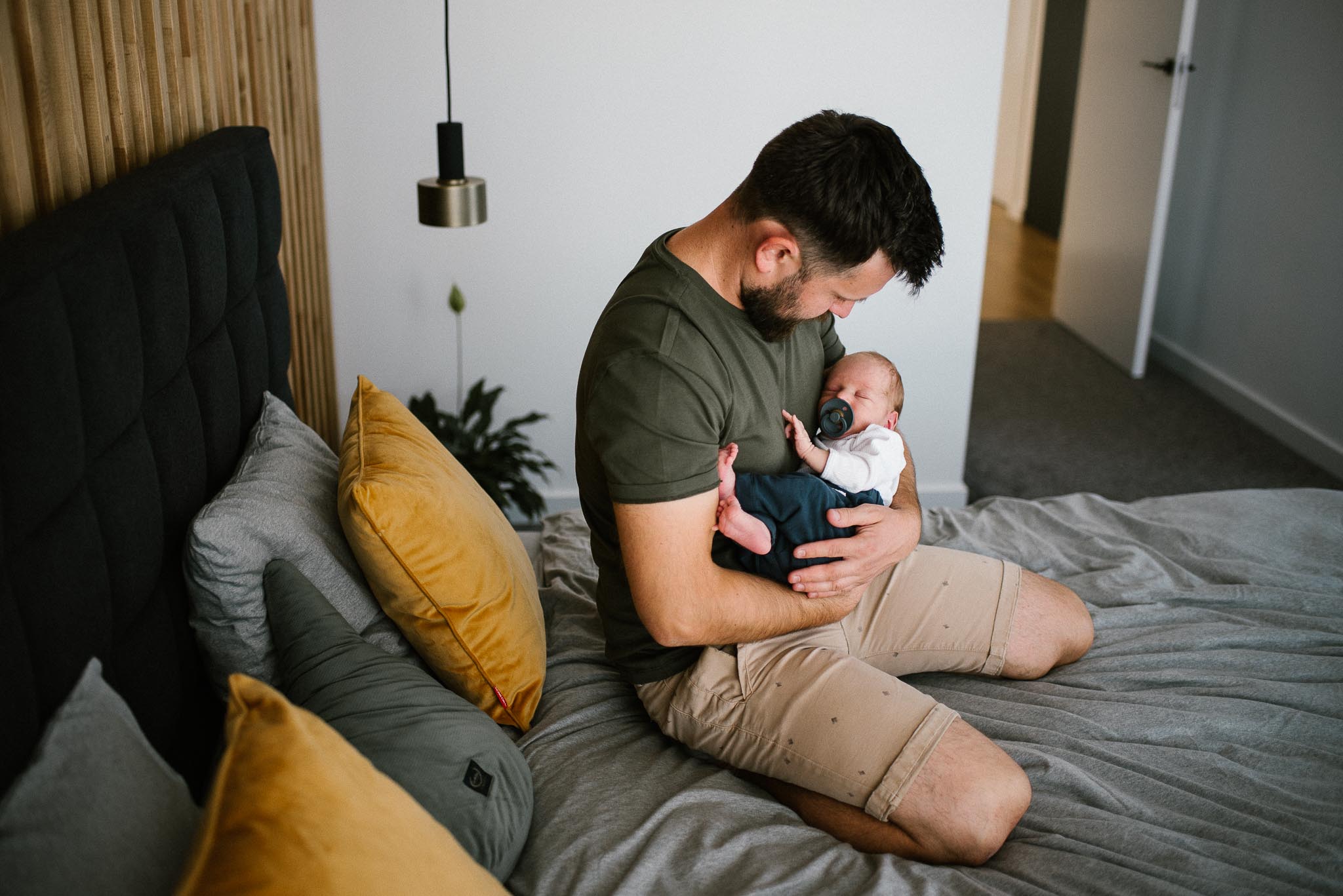 tata trzyma noworodka na rękach - sesja noworodkowa lifestyle w Poznaniu