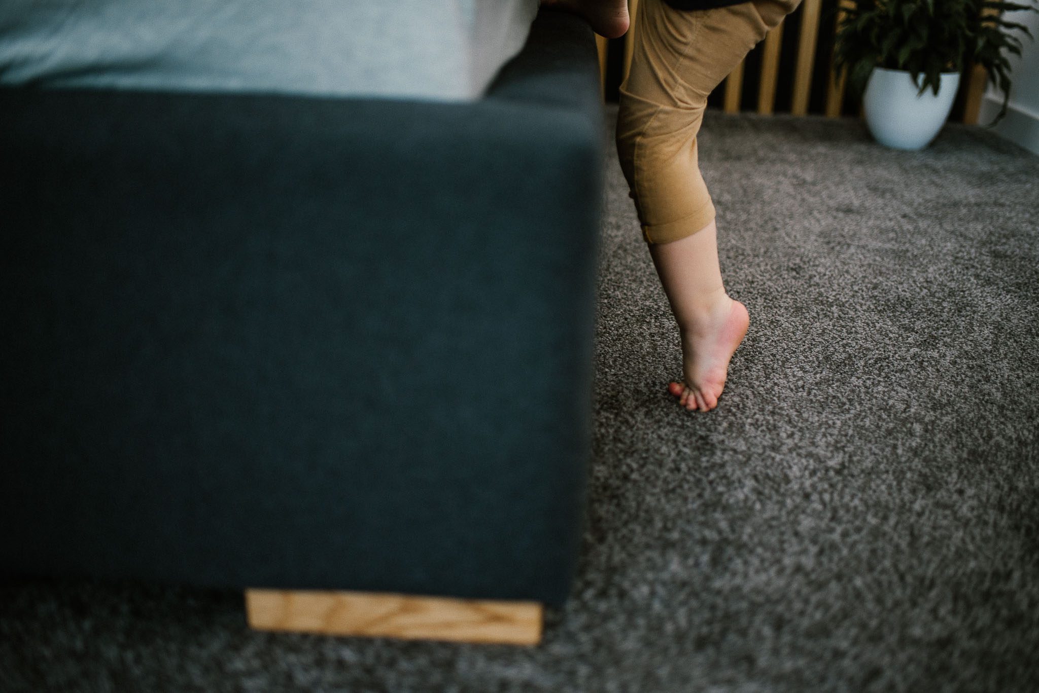 Chłopiec wchodzi na łóżko - sesja noworodkowa lifestyle w Poznaniu