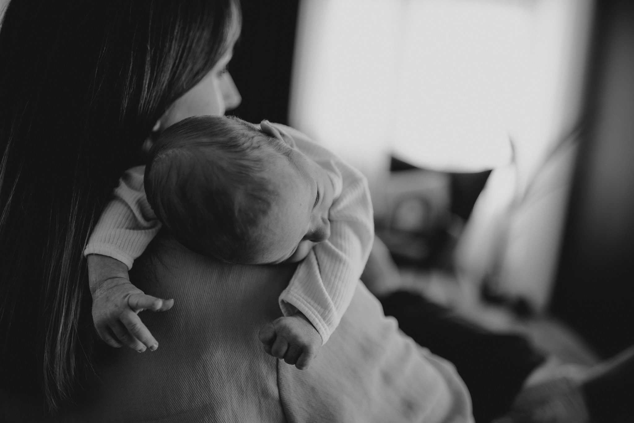 Mama trzyma noworodka na rękach - sesja noworodkowa lifestyle w Poznaniu