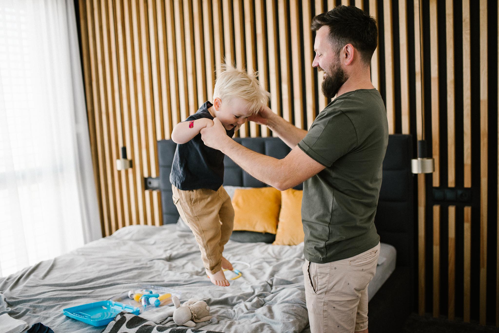 tata z synkiem skaczą po łóżku - sesja noworodkowa lifestyle w Poznaniu