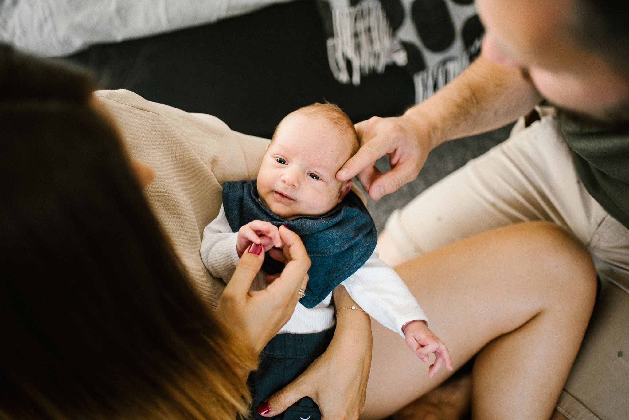 Rodzice patrzą na niemowlaka - sesja noworodkowa lifestyle w Poznaniu