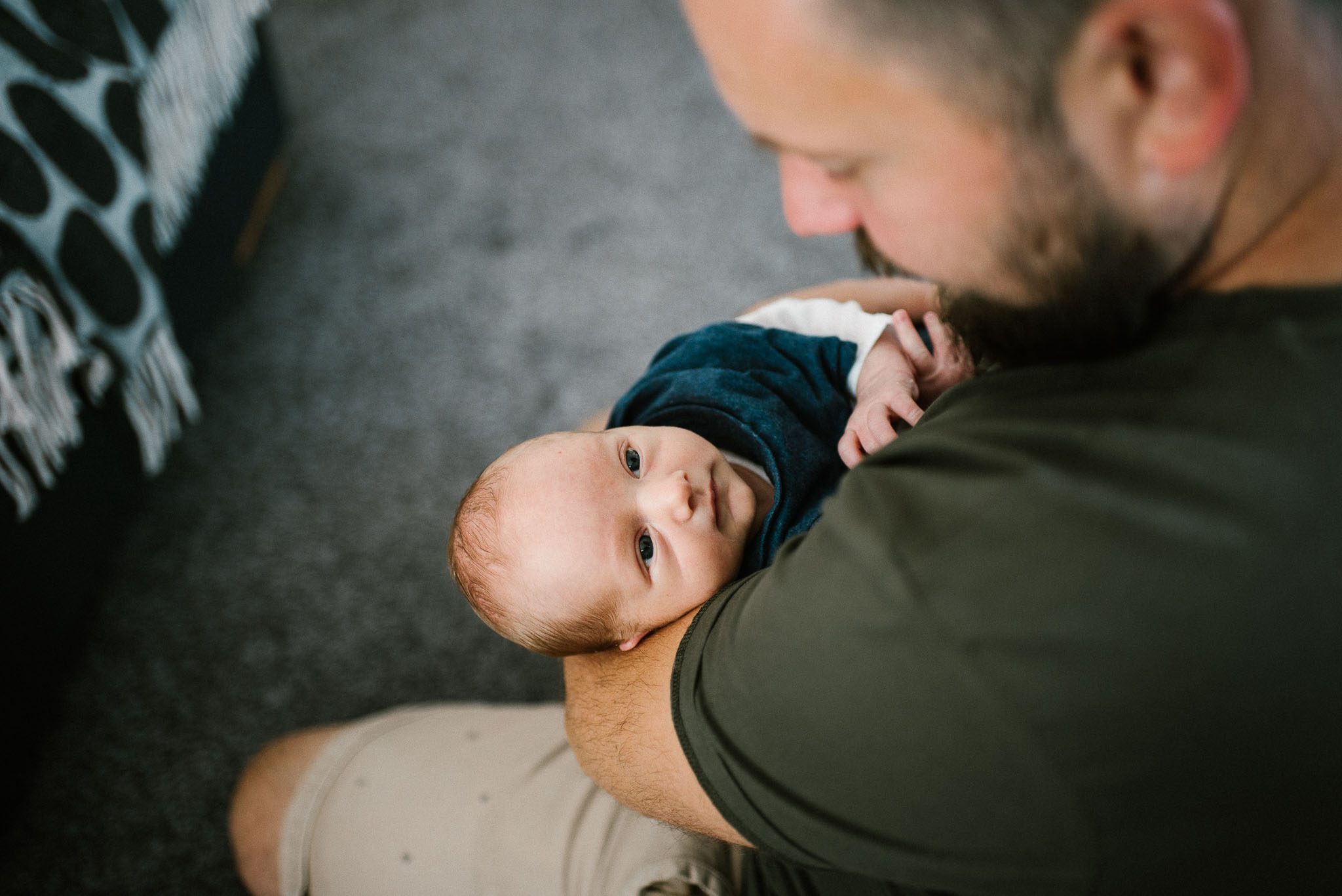 Tata trzyma noworodka na rękch - sesja noworodkowa lifestyle w Poznaniu