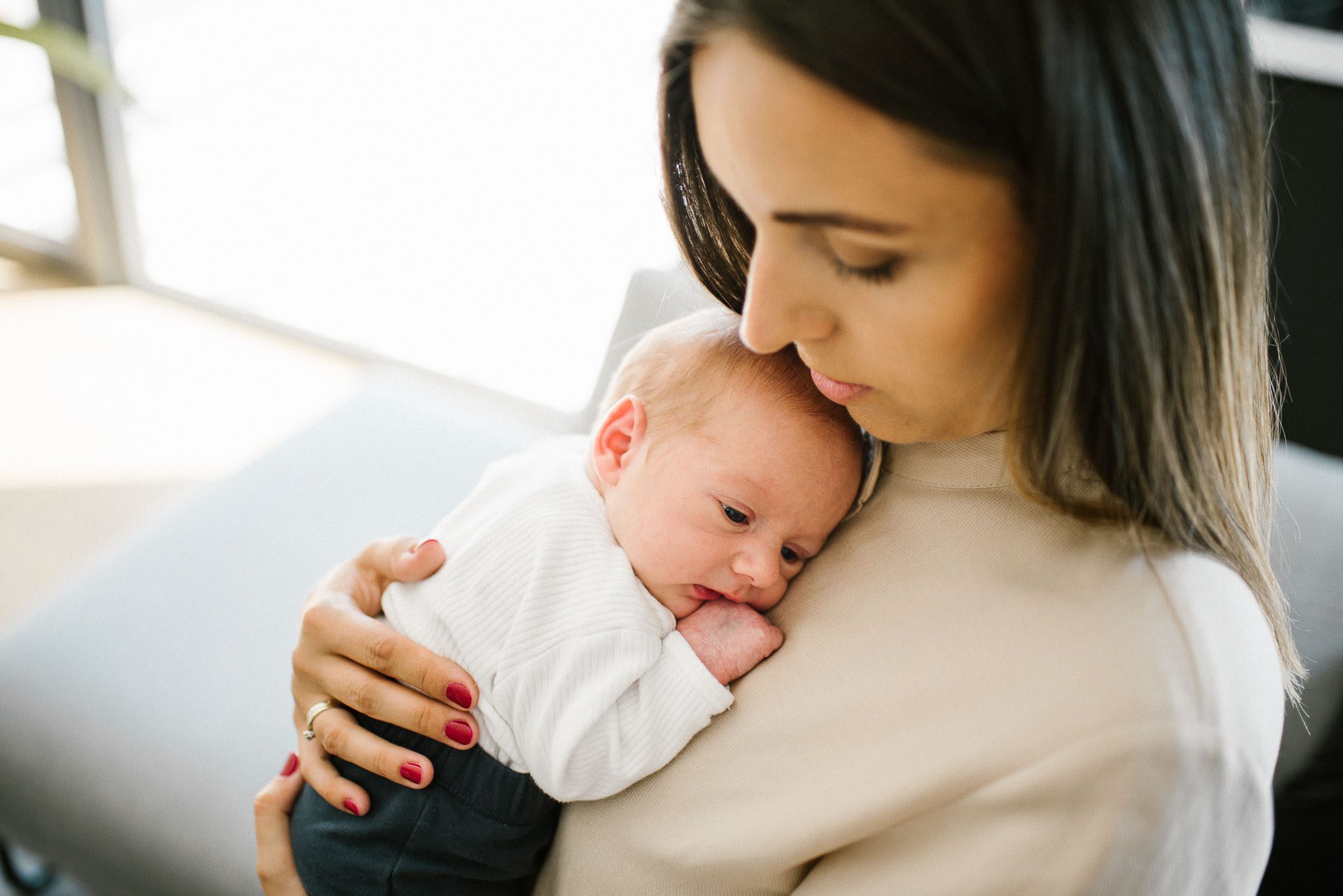mama trzyma noworodka na rękach - sesja noworodkowa lifestyle w Poznaniu