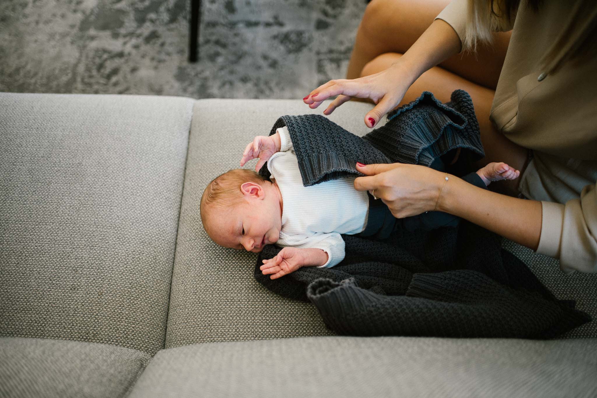 Noworodek leży na kanapie - sesja noworodkowa lifestyle w Poznaniu