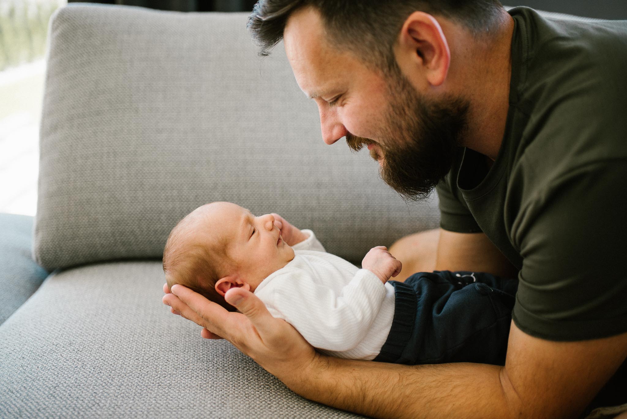 tata patrzy na noworodka - sesja noworodkowa lifestyle w Poznaniu