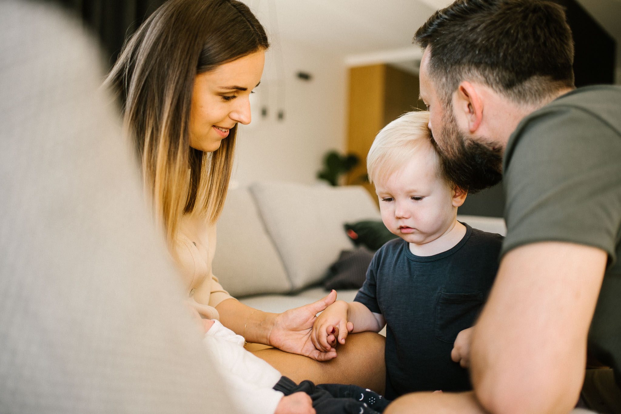 Rodzina z noworodkiem na kanapie - sesja noworodkowa lifestyle w Poznaniu