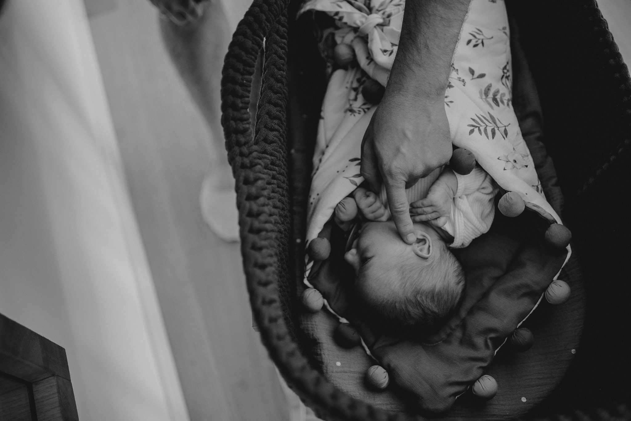 Tata dotyka noworodka - sesja noworodkowa lifestyle w Poznaniu