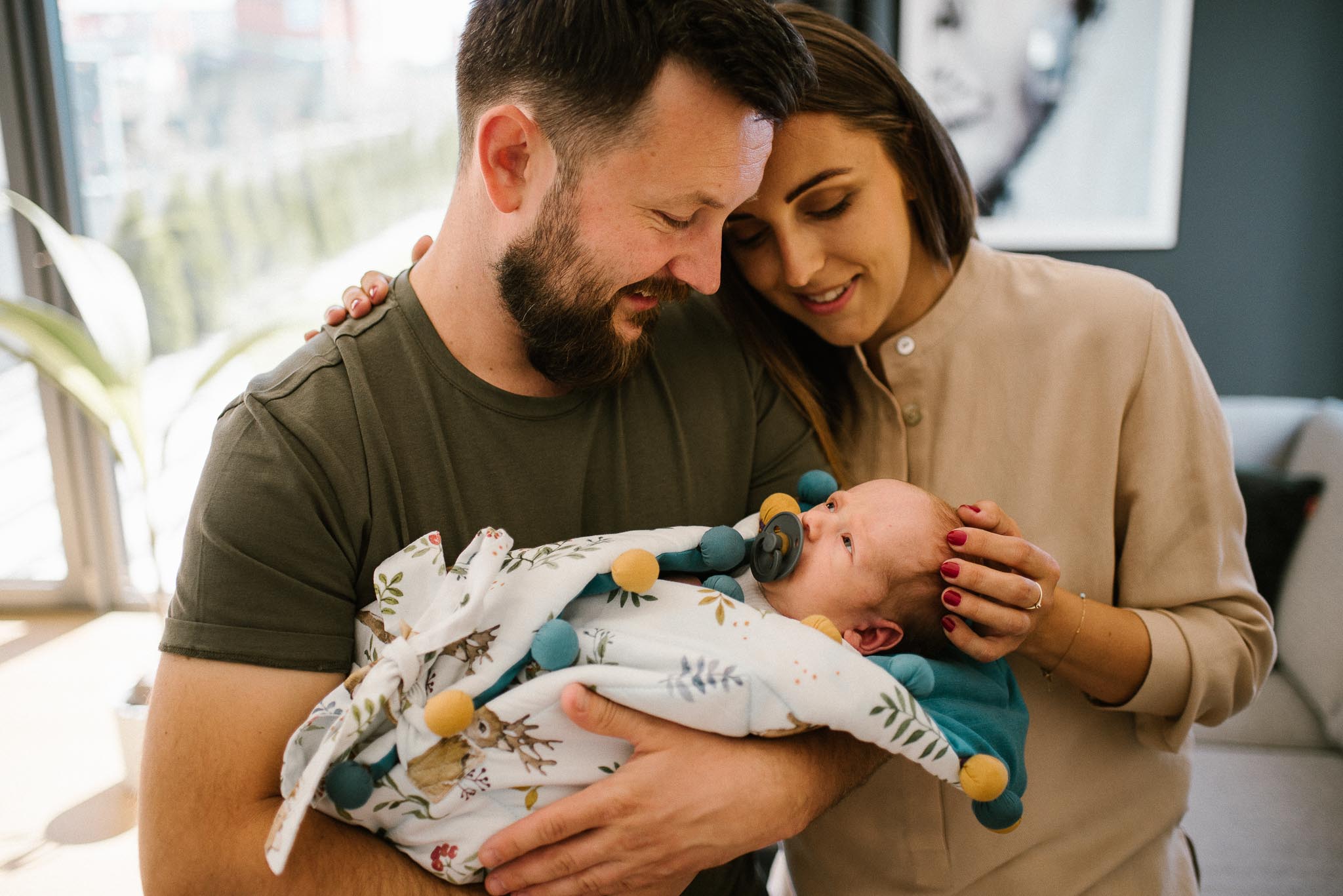 Rodzice patrzą na noworodka - sesja noworodkowa lifestyle w Poznaniu
