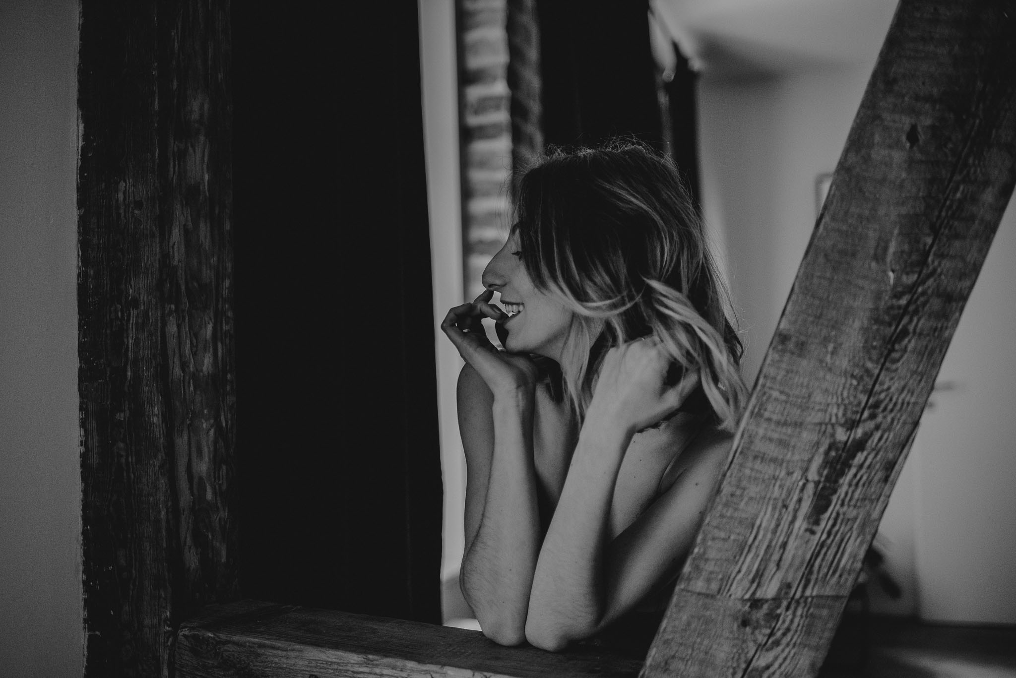 Kobieta w&nbsp;bieliźnie opiera się o&nbsp;drewniane kolumny w&nbsp;apartamencie w&nbsp;Poznaniu