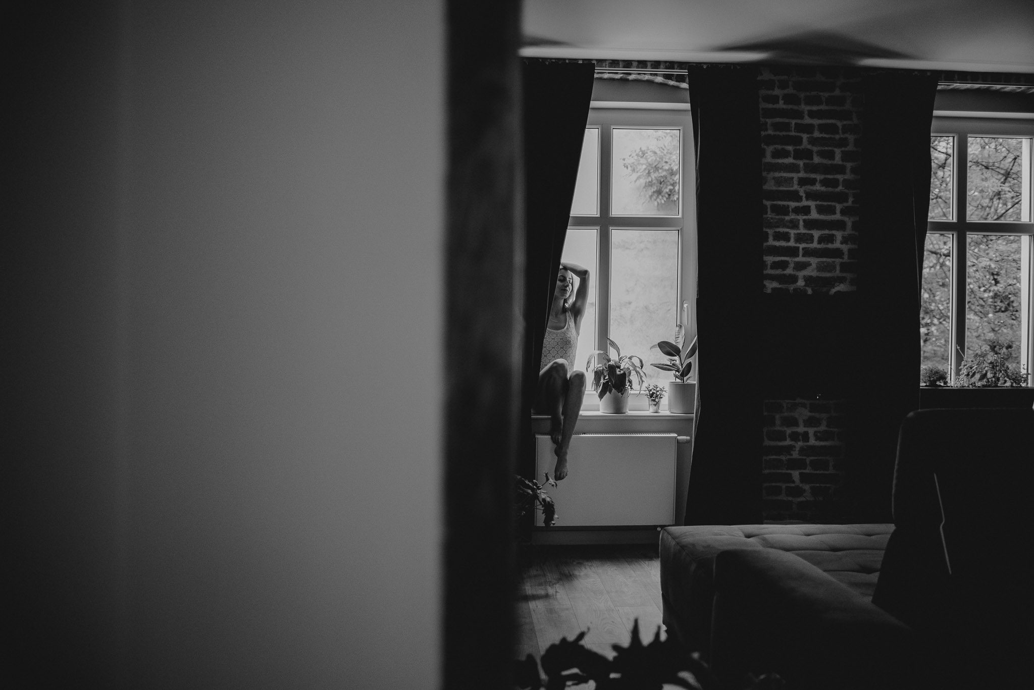 Kobieta w&nbsp;bieliźnie siedzi na&nbsp;parapecie - sesja kobieca w&nbsp;apartamencie w&nbsp;Poznaniu