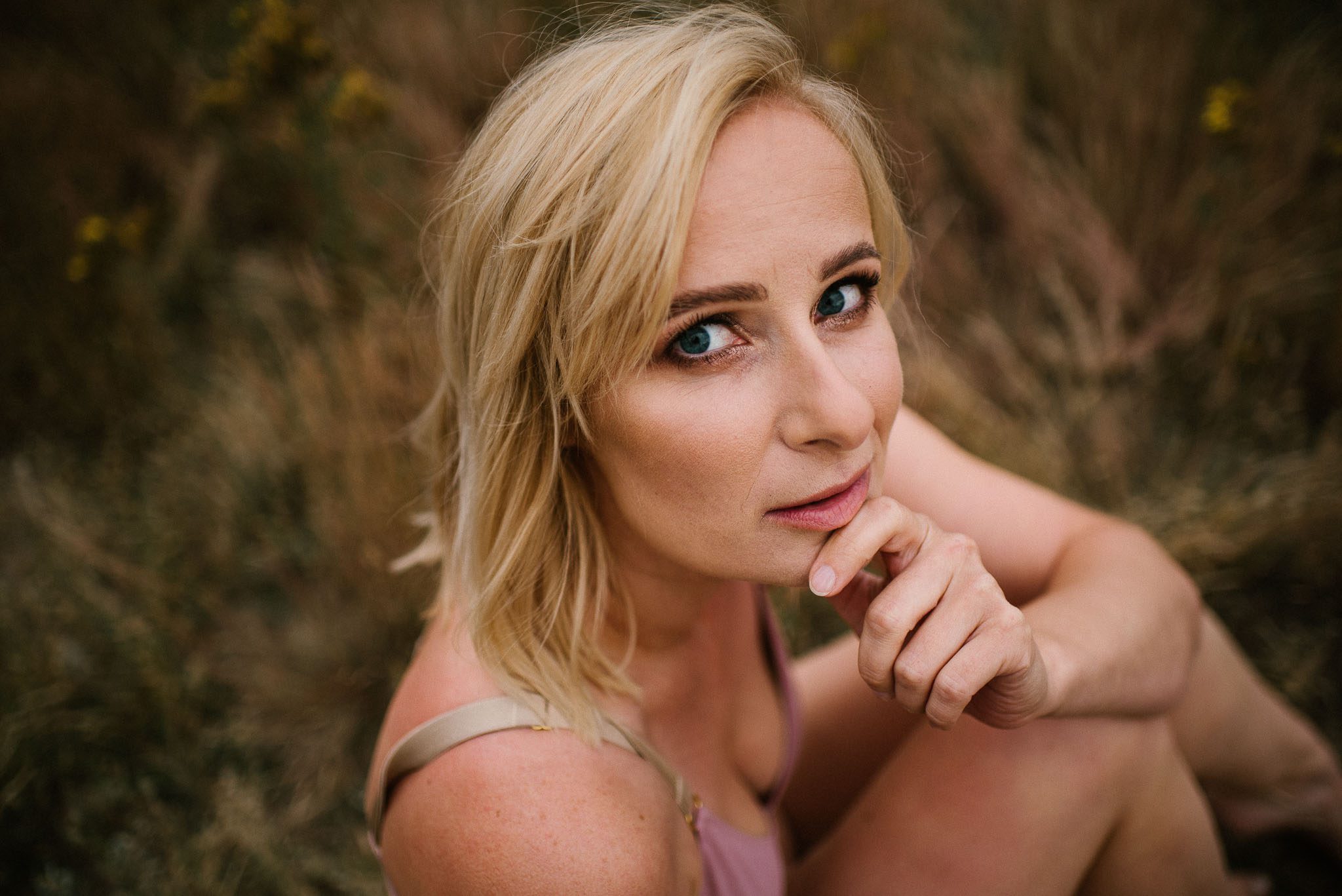 Kobieta na&nbsp;łące w&nbsp;bieliźnie, zbliżenie na&nbsp;twarz - sesja kobieca sensualna w&nbsp;plenerze Poznań