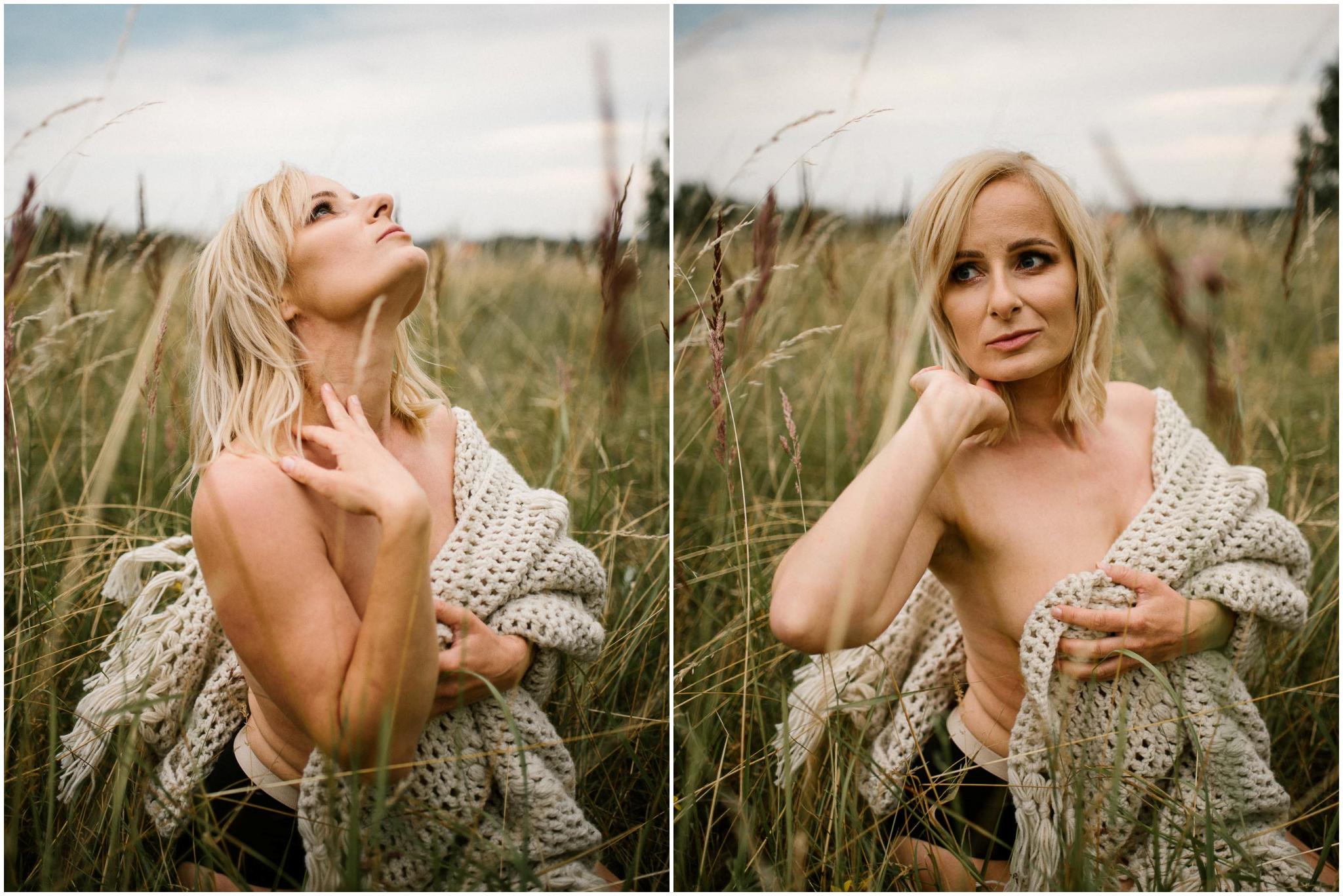 Kobieta zasłania piersi siedząc na&nbsp;łące - sesja kobieca sensualna w&nbsp;plenerze Poznań