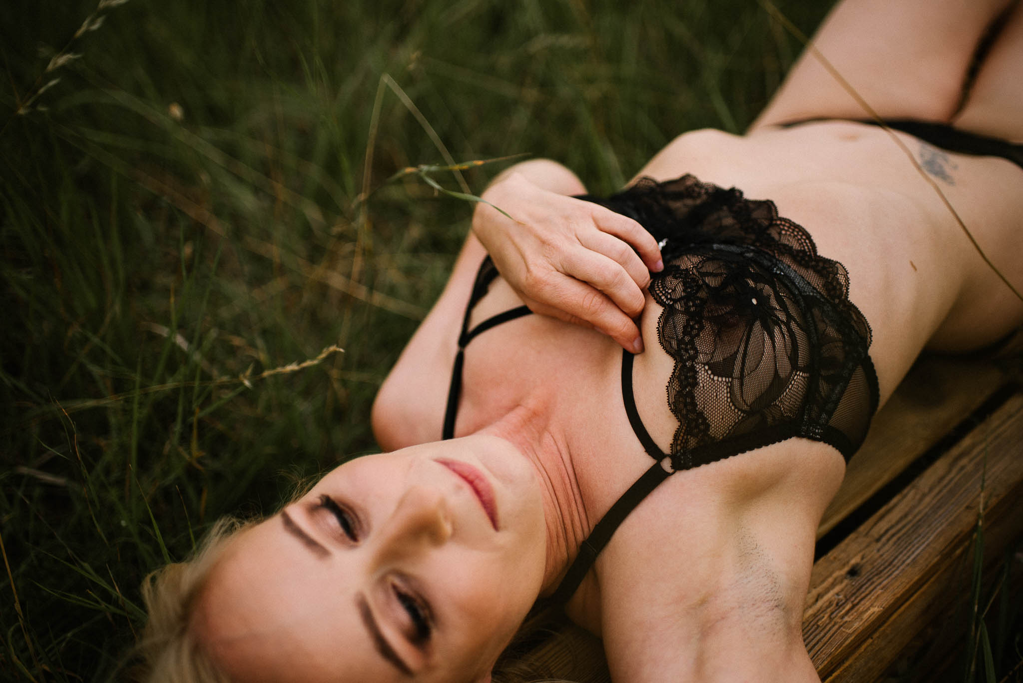 Kobieta w&nbsp;bieliźnie leży na&nbsp;łące - sesja kobieca sensualna w&nbsp;plenerze Poznań