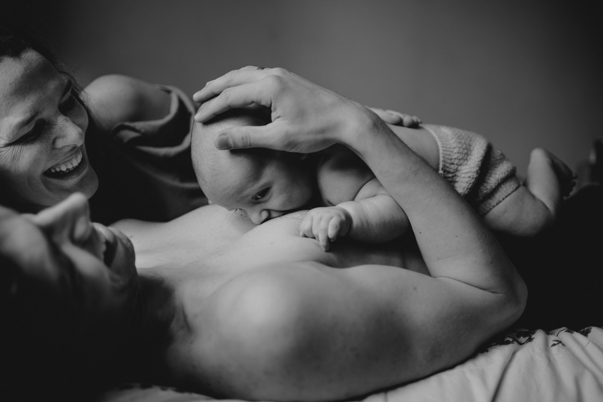 Niemowlę gryzie tatę w&nbsp;pierś - sesja niemowlęca lifestyle w&nbsp;domu Poznań