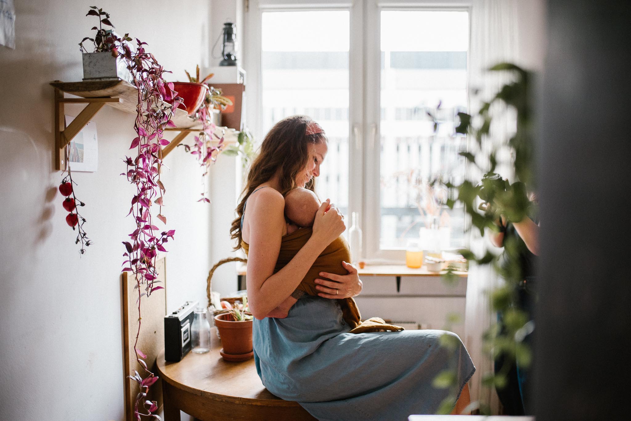 Mama nosi niemowlę w&nbsp;chuście - Sesja niemowlęca lifestyle w&nbsp;domu Poznań